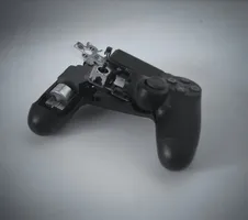 A game controller that has been broken open, with part of the left half missing and its contacts exposed.