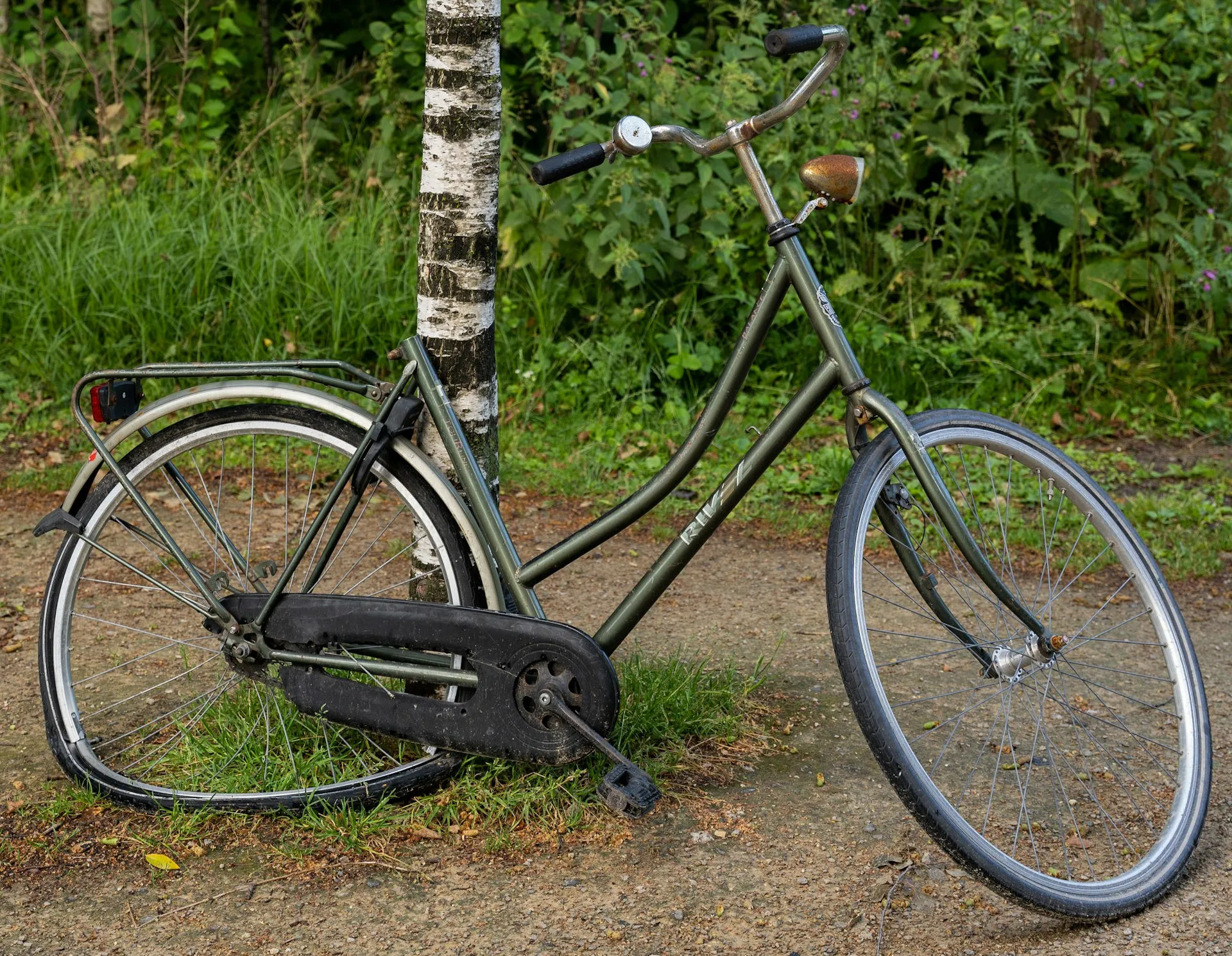 A bicycle with rusted parts and a damaged and bent rear wheel.