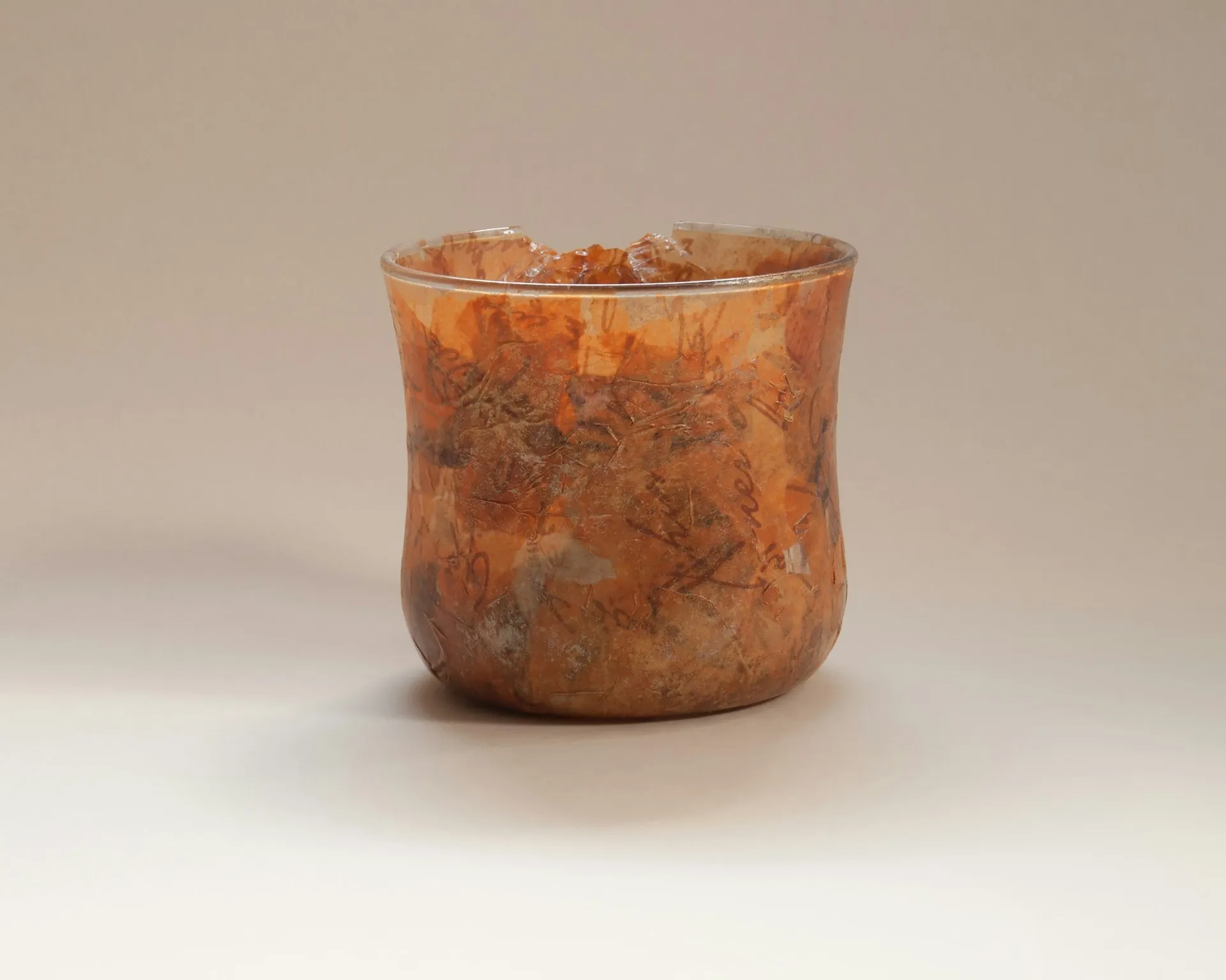 A brown ceramic vase with a chip out of the rim.