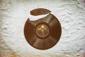 A 78 RPM vinyl record with a chunk cut out from one side.