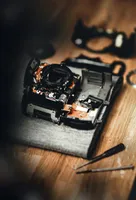 A broken and largely-disassembled black camera.