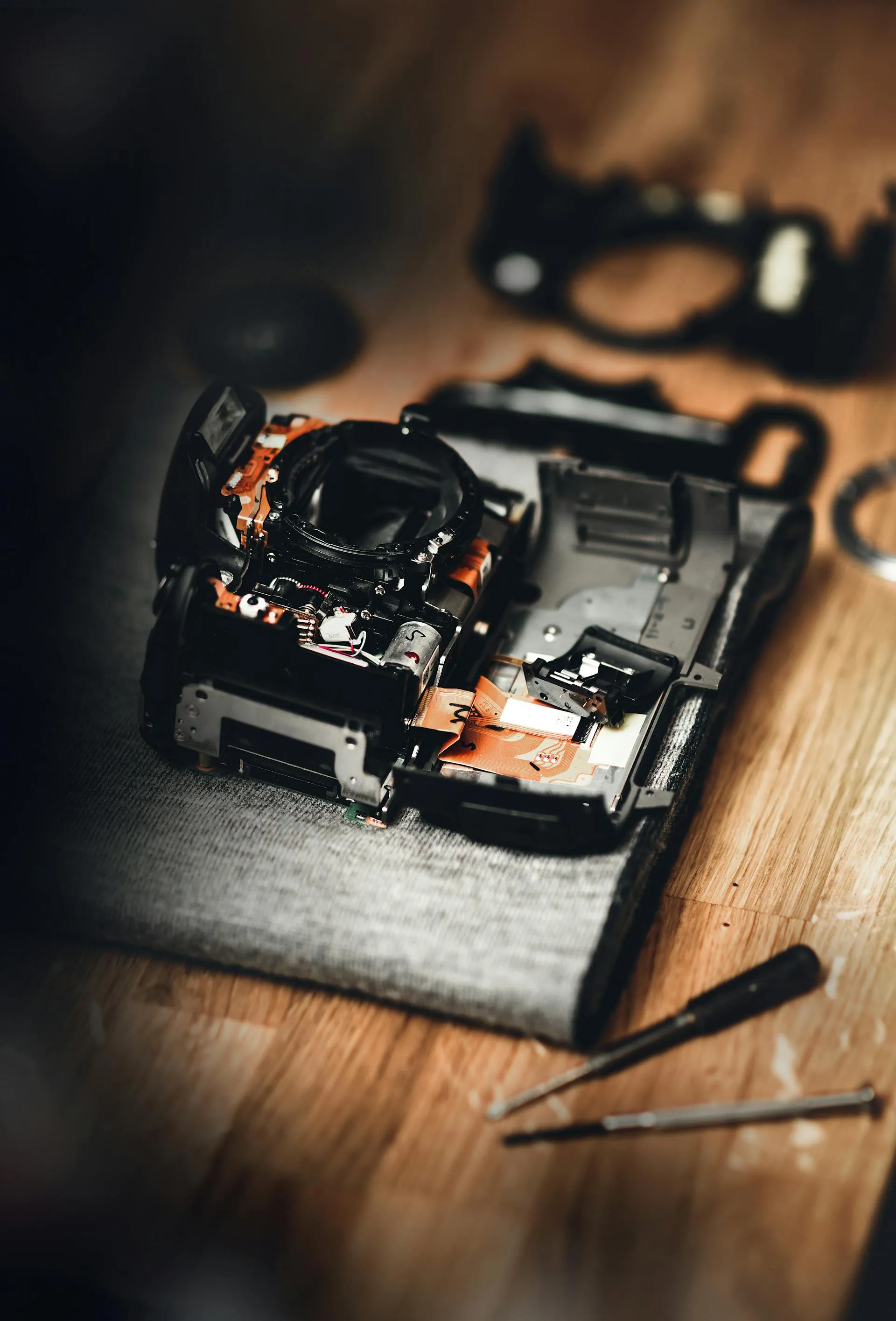 A broken and largely-disassembled black camera.