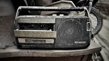 A worn-out portable radio and cassette player with the cassette door open.